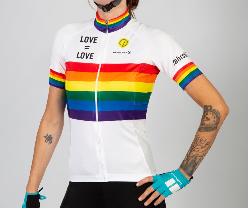Eine Frau mit tätowierten Armen trägt das Fahrradtrikot von fahrstil.