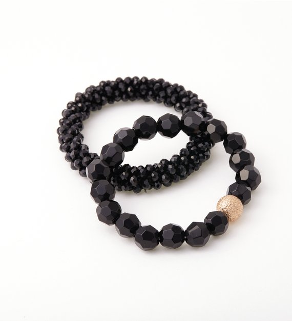 Zwei Armbänder aus schwarzen Schmuckperlen mit goldenem Detail von jewellery doctor.