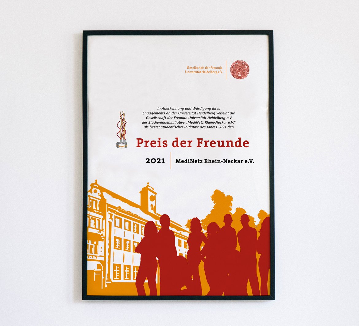 Die Urkunde vom Preise der Freunde in einem Bilderrahmen mit einer Abbildung der alten Universität Heidelberg und davorstehenden Menschen.