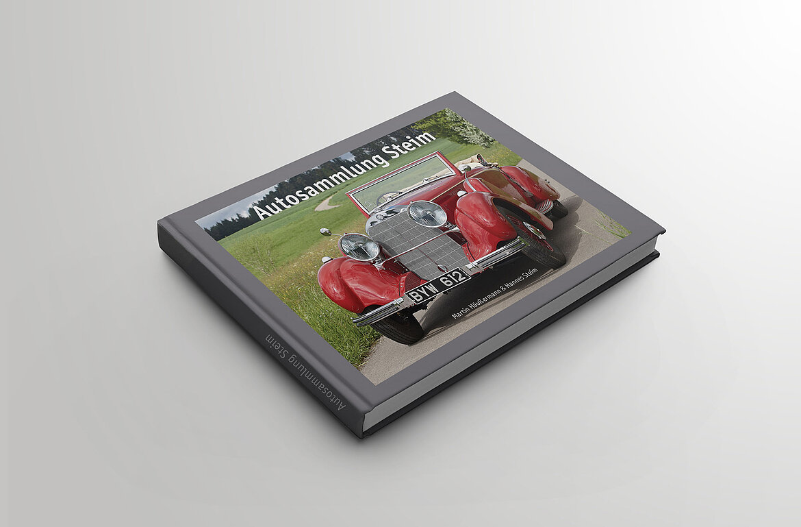 Der geschlossene Bildband der Autosammlung Steim mit der Fotografie eines roten Oldtimers.