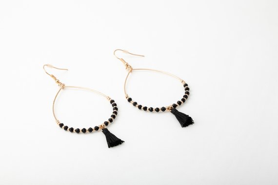 Zwei goldene Ohrringe mit schwarzen Details von jewellery doctor.