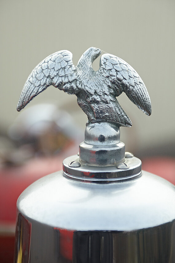 Ein Adler aus Metall als Detail des alten Feuerwehrautos im Bildband der Autosammlung Steim.
